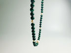 The Bì(碧) handcrafted necklace featuring lustrous white pearls and vibrant green malachite stones arranged in elegant pattern